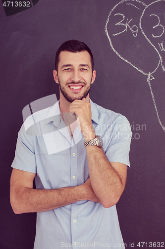 Image of portrait of man in front of black chalkboard