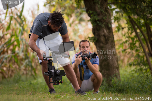 Image of young videographer recording while woman doing yoga exercise