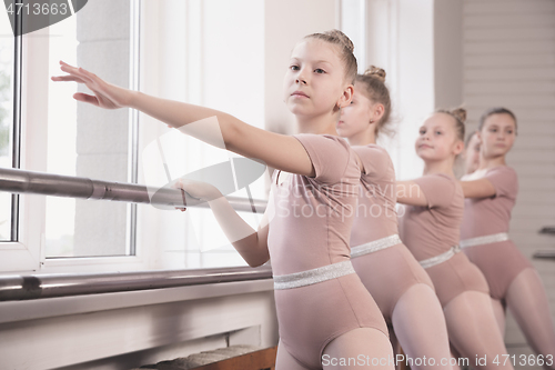 Image of Young graceful female ballet dancers dancing at training studio