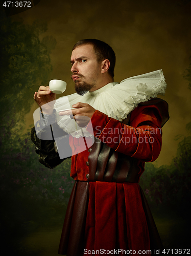 Image of Young man as a medieval knight on dark background