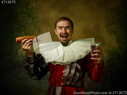 Image of Young man as a medieval knight on dark background