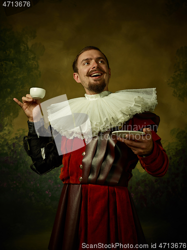 Image of Young man as a medieval knight on dark background