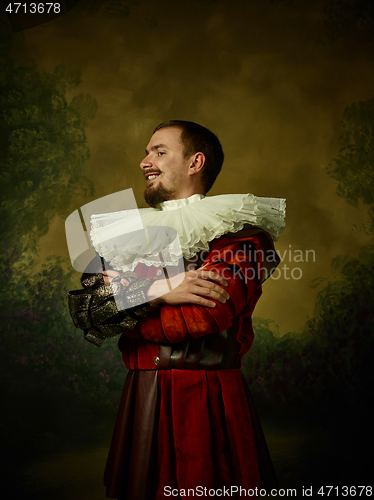 Image of Young man as a medieval knight on dark background