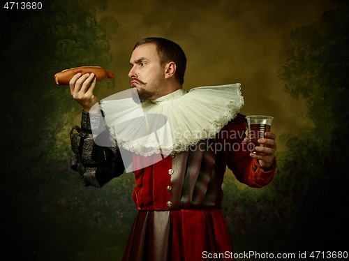 Image of Young man as a medieval knight on dark background