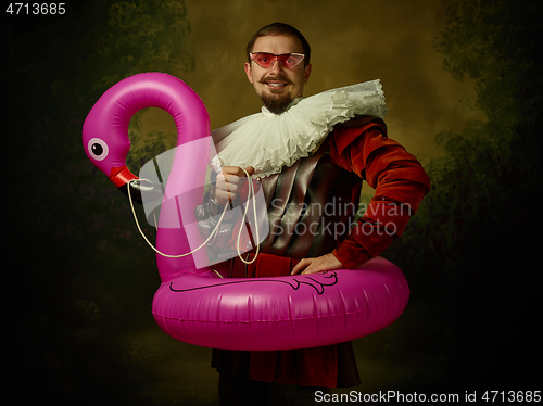 Image of Young man as a medieval knight on dark background