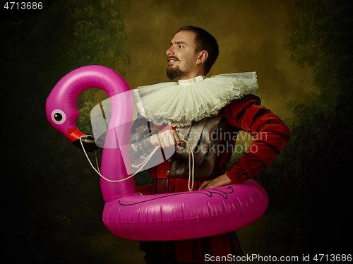 Image of Young man as a medieval knight on dark background