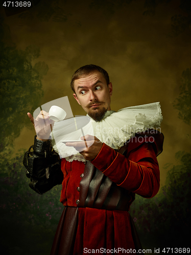 Image of Young man as a medieval knight on dark background