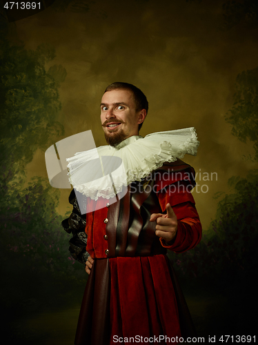 Image of Young man as a medieval knight on dark background