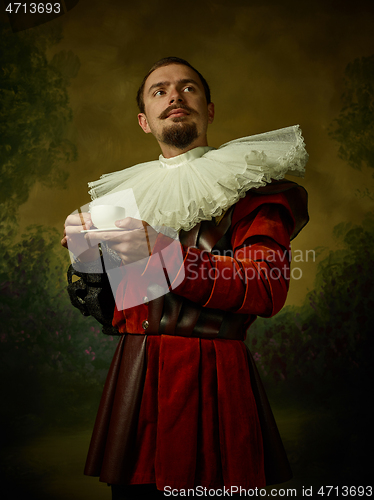 Image of Young man as a medieval knight on dark background