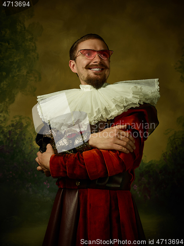 Image of Young man as a medieval knight on dark background