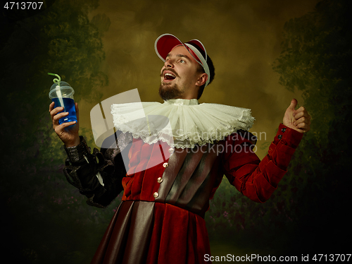 Image of Young man as a medieval knight on dark background