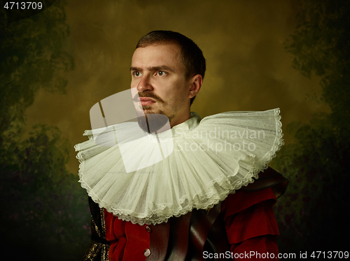 Image of Young man as a medieval knight on dark background