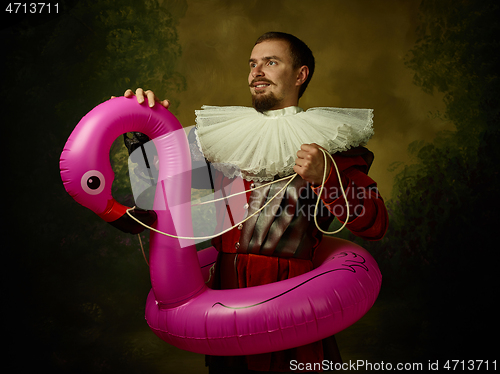 Image of Young man as a medieval knight on dark background