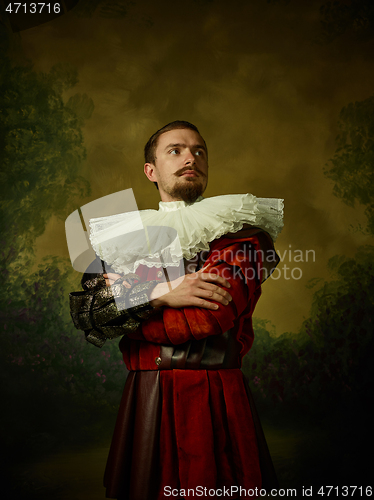 Image of Young man as a medieval knight on dark background