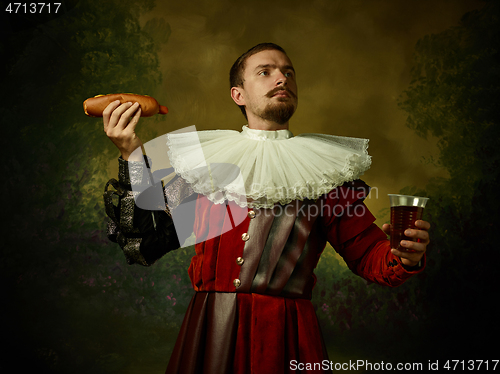 Image of Young man as a medieval knight on dark background