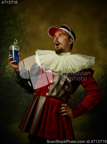 Image of Young man as a medieval knight on dark background