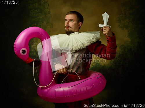 Image of Young man as a medieval knight on dark background