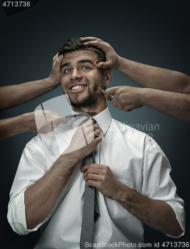 Image of A young man surrounded by hands like his own thoughts