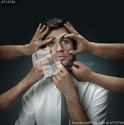 Image of A young man surrounded by hands like his own thoughts