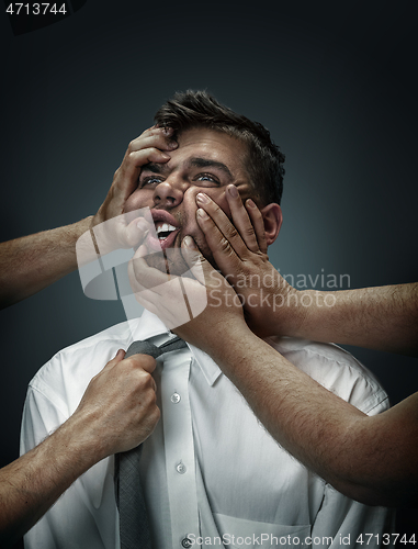 Image of A young man surrounded by hands like his own thoughts