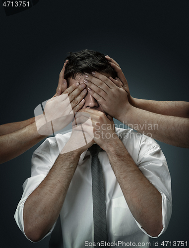 Image of A young man surrounded by hands like his own thoughts
