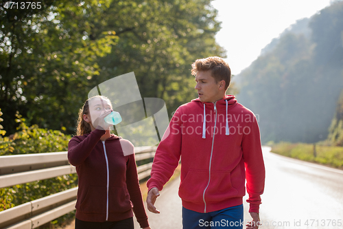 Image of young couple jogging along a country road