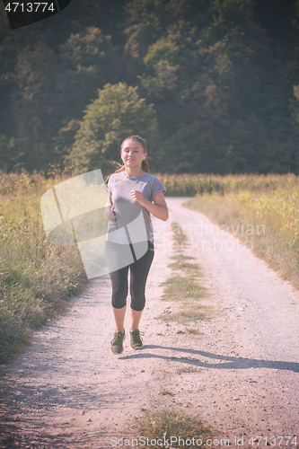 Image of woman jogging along a country road