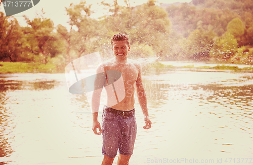 Image of man with a bare torso splashing water