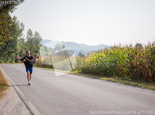 Image of happy couple jogging along a country road