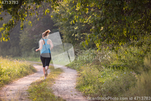 Image of woman jogging along a country road