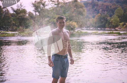 Image of man with a bare torso splashing water