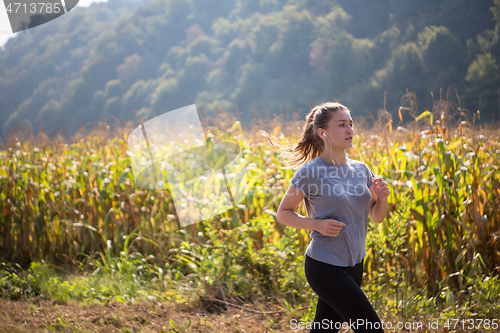 Image of woman jogging along a country road