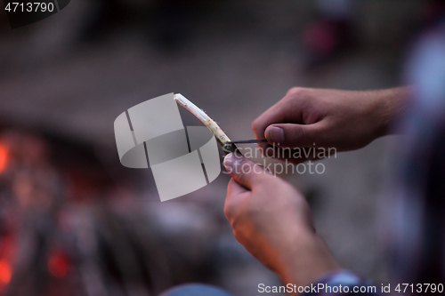 Image of young friends relaxing around campfire