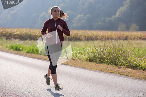 Image of woman jogging along a country road