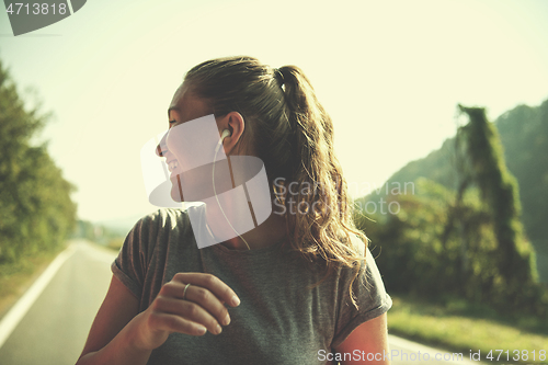 Image of woman jogging along a country road