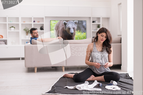 Image of pregnant couple checking a list of things for their unborn baby