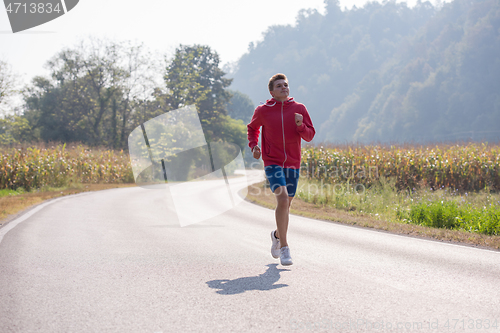 Image of man jogging along a country road