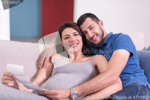 Image of pregnant couple looking baby\'s ultrasound