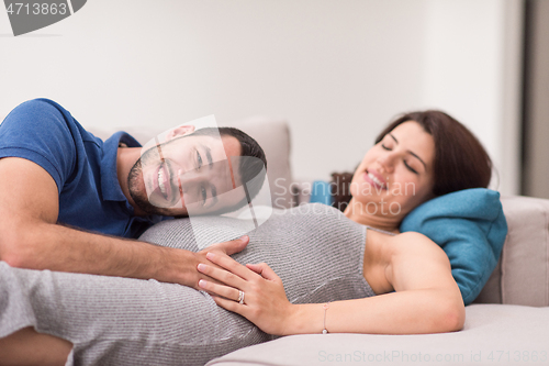 Image of future dad listening the belly of his pregnant wife