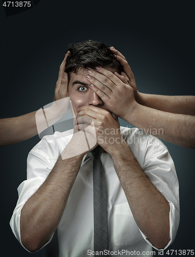 Image of A young man surrounded by hands like his own thoughts