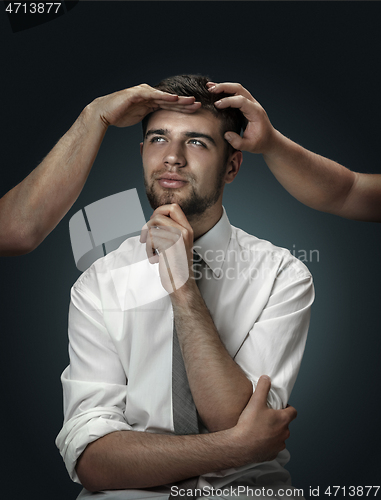 Image of A young man surrounded by hands like his own thoughts