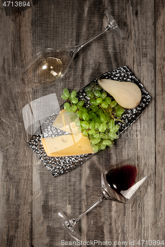 Image of A bottle and glasses of red and white wine with fruits