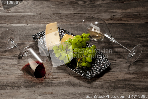 Image of A bottle and glasses of red and white wine with fruits