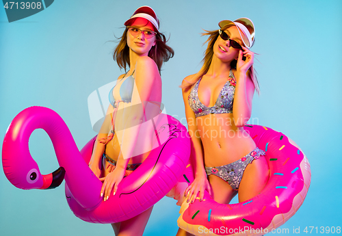 Image of Beautiful girls isolated on blue studio background in neon light