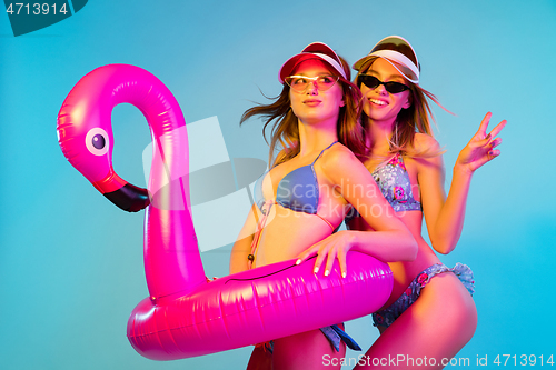 Image of Beautiful girls isolated on blue studio background in neon light