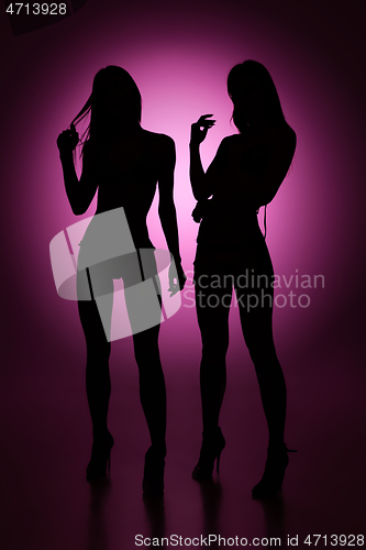 Image of Full-length female silhouettes on purple background