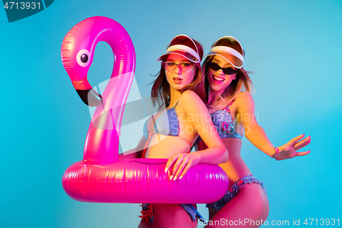 Image of Beautiful girls isolated on blue studio background in neon light