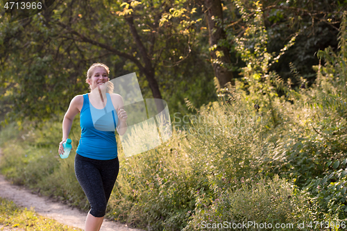 Image of woman jogging along a country road