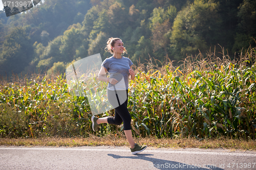 Image of woman jogging along a country road