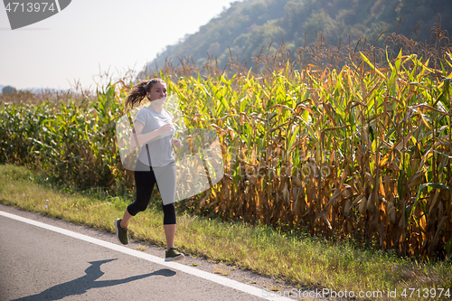 Image of woman jogging along a country road